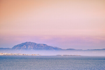 Schoonheidslandschap van valdevaqueros-duin in tarifa cadiz op kalme zee met mist in achtergrondgeluid tarifa stad en jebel musa kleurrijke hemel