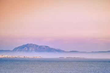 Photo sur Plexiglas Plage de Bolonia, Tarifa, Espagne Paysage de beauté de la dune de valdevaqueros à tarifa cadix sur une mer calme avec du brouillard en arrière-plan ville de tarifa et jebel musa ciel coloré