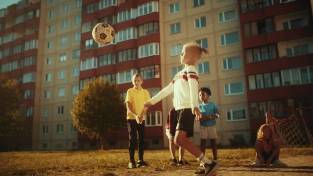 Young Diverse Kids Playing Soccer in the Backyard. Excited Multicultural Boys and Girls Playing Kick-Ups, Juggling and Controlling the Ball in the Air. Concept of Sports, Childhood, Friendship.