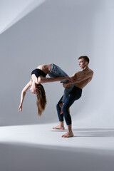 Emotional beautiful couple of modern ballet dancers in jeans doing choreographic elements. Concept...