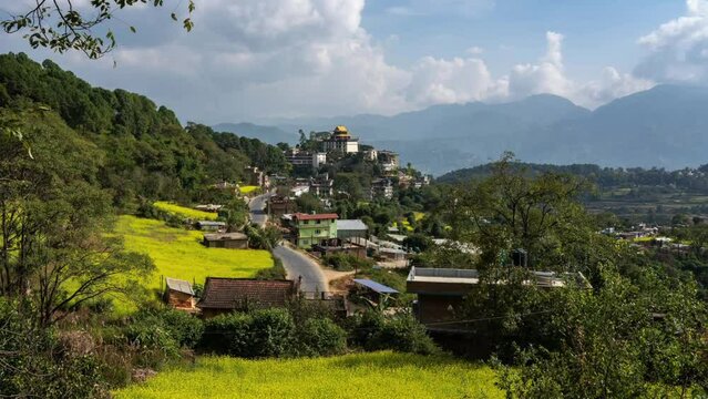 A zooming time-lapse view of the Neydo Tashi Choling Monastery in the small town of Dakshinkali in Nepal surrounded with mustard fields.