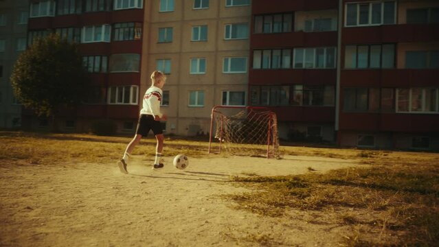 Young Talented Boy Practising Dribbling with Soccer Ball and Shooting Penalty Kicks. Talented Football Player Practicing Free Kicks in the Backyard. Slow Motion Footage.
