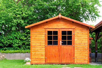 Frontal view of wooden garden shed in a summer - 544329924