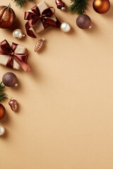 Neutral beige Christmas background with gift boxes, brown baubles, festive decorations, fir branches.