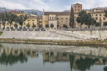 Fototapeta na wymiar The bank of the Adige in Verona with buildings that are reflected on the water