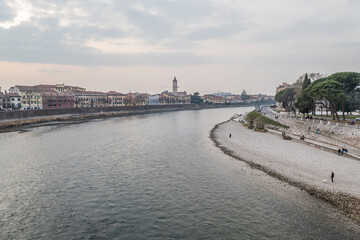 Fototapeta na wymiar The Adige river and the panorama of Verona seen from the Castelvecchio bridge