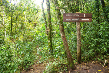 Sign directing adventurers to broken stone and round stone trails in Monte Verde, Minas Gerais.