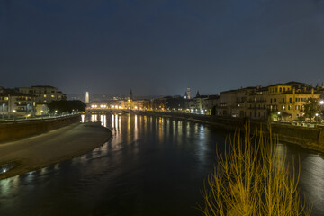 The Adige river and the panorama of Verona seen from the Castelvecchio bridge illuminated at night