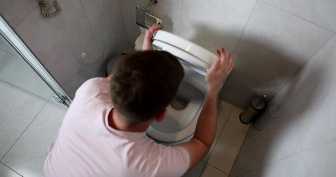 Man opening toilet lid and vomiting at home 4k movie slow motion 
