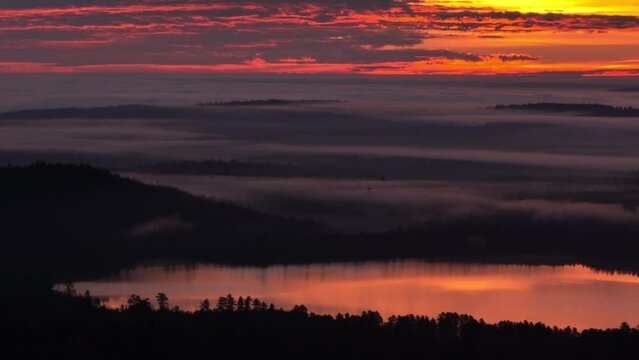 Eye-catching golden hour sunrise illuminates stratus clouds over Monson Lake