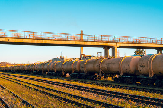 Long Train With Tank Wagons Behind Each Other In A Row On A Track Next To Empty Rails. Crude Oil Or Fuel Transportation.