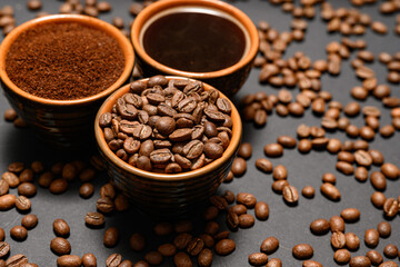 Freshly ground and prepared black coffee on a black background.