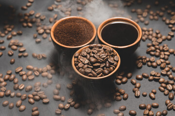 Cups of coffee and roasted coffee beans on a black background in a pair.