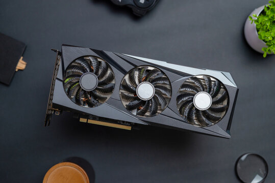 Gaming graphics card above a black desk. Top view, flat lay composition. Rendering and gaming hardware