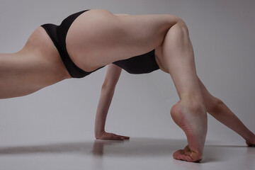 the ballerina sexually demonstrates stretching and plasticity sitting on a half-step with a bend of...
