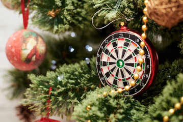 Close up picture of christmas ornaments on green artificial Xmas tree. Red and golden glass darts...