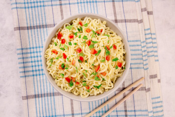 Instant noodles in bowl on gray background