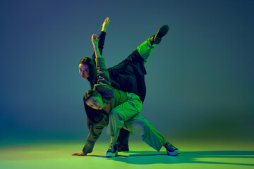 Energy. Stylish young girls dancing casual clothes dancing experimental style dance over gradient...