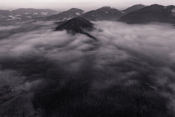 A panoramic view from above of the mountain peaks in thick clouds.