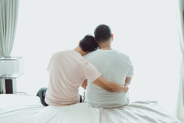 Two gay Asian men in the bedroom consoling support each other on. concept Happy lifestyle and happy house Embrace homosexuality. make a men love scene ,LGBT gay couple relationship lifestyle concept