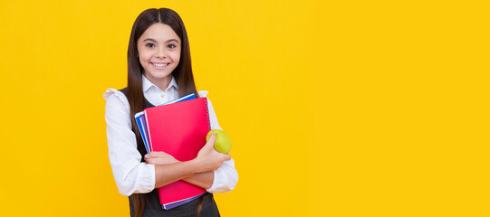 Happy schoolchild in uniform hold apple and books yellow background, back to school. Banner of schoolgirl student. School child pupil portrait with copy space.