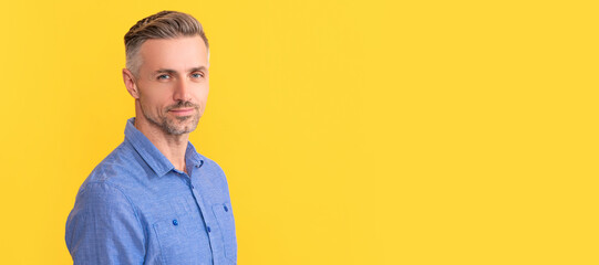 Man face portrait, banner with copy space. smiling mature man with graying hairstyle on yellow...