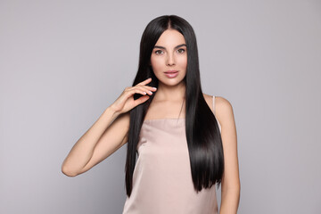 Naklejka premium Portrait of beautiful young woman with healthy strong hair on light grey background