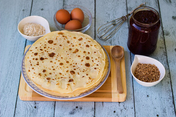 Thin pancakes on blue rustic table