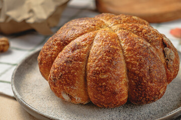 Craft pumpkin bread with pumpkin seeds . Homemade wholemeal rye yeast-free bread on a white striped towel
