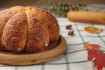 Craft pumpkin bread with pumpkin seeds . Homemade wholemeal rye yeast-free bread on a white striped towel
