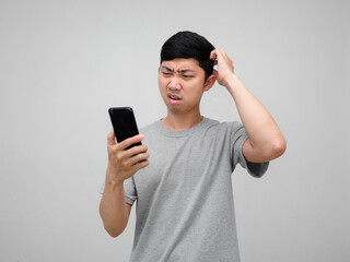 Fototapeta premium Asian man feels confused gesture scratch head looking at mobile phone isolated