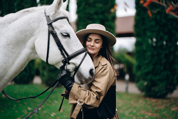 Obraz premium A young woman hugs a white horse.