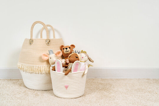 Beige Toy Storage Baskets in the children's room. Cloth stylish Baskets with  toys and rag dolls. Organizing and Storage Ideas in nursery. Clean up toys and reduce the clutter. House cleaning.
