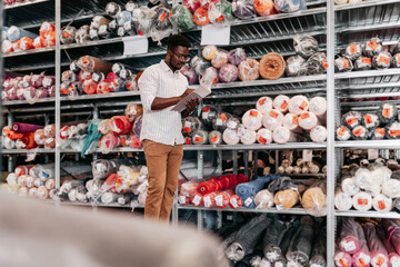 Handsome black man working at his fashion designer studio. Small business concept.