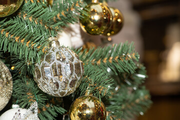 Golden Christmas balls and toys on the New Year and Christmas tree. Сlose up