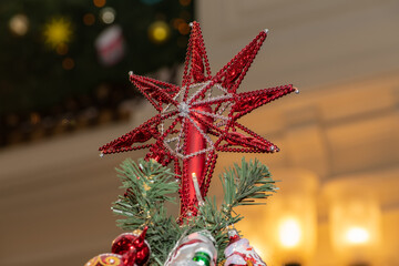 Red star at the top of the New Year and Christmas tree
