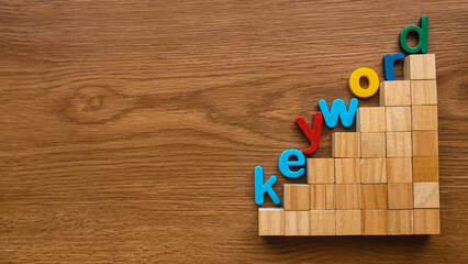 Colorful alphabet of word keyword on a ladder of wooden cube.