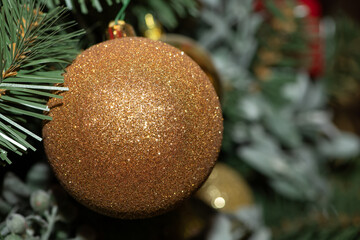 Christmas ball in gold color on a Christmas tree. Сlose up