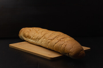 white bread lies on a cutting board on a wooden background