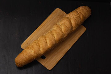 white bread lies on a cutting board on a wooden background