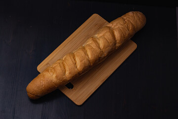 white bread lies on a cutting board on a wooden background