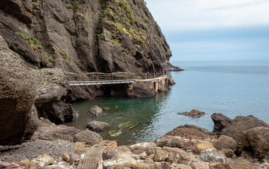 Bridge and rocky coastlines, mountains, and blue ocean waters at the shore of Ulleungdo Island South Korea
