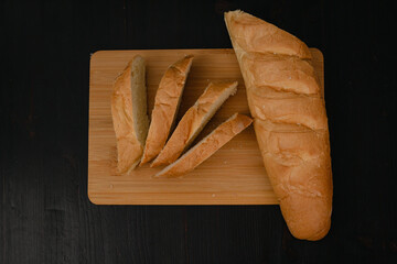 Sliced white bread lies on a cutting board on a wooden background