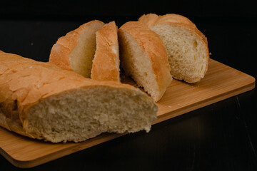 Sliced white bread lies on a cutting board on a wooden background