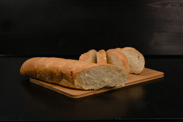 Sliced white bread lies on a cutting board on a wooden background