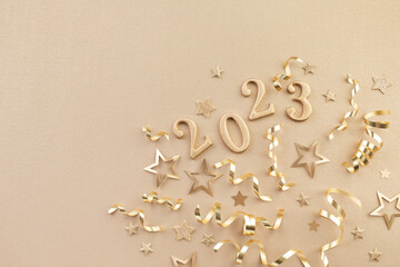 Holiday background with golden Christmas decorations and New year 2023 numbers and confetti stars...