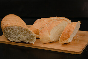 Sliced white bread lies on a cutting board on a wooden background