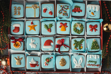 Delicious Christmas cookies set in a gift box. Advent calendar to count the days in anticipation of Christmas. Gingerbread cookies with festive blue icing on the Christmas background