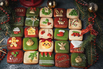 Delicious Christmas cookies set in a gift box. Advent calendar to count the days in anticipation of Christmas. Gingerbread cookies with festive red and green icing on the Christmas background