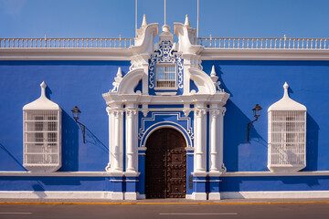 Traditional blue architecture with white painted windows railings and adorned main door, Trujillo, Peru
